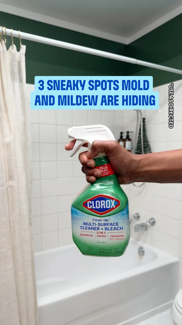 3 SNEAKY SPOTS MOLD AND MILDEW ARE HIDING - USE AS DIRECTED. Hand holding Clorox Clean-Up Multi-Surface Cleaner + Bleach spray bottle in bathroom.